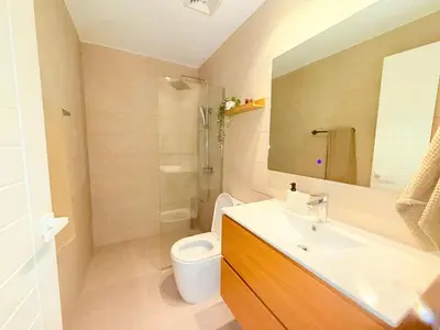 a bathroom with a sink and a toilet and a mirror at Gardenia Beachside Living in Punta Cana
