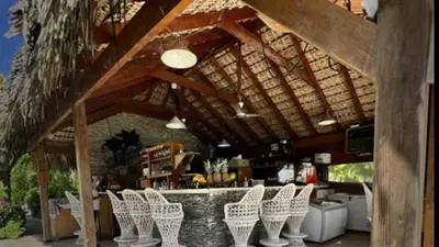 a group of white chairs sitting in front of a bar at Casa Lio in Boca Chica