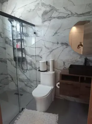 a bathroom with a toilet and a glass shower at Sky 01 M11 in Santo Domingo