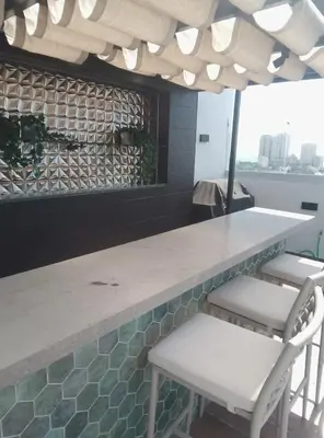 a bar with two white chairs and a counter at Sky 01 M11 in Santo Domingo
