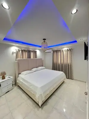a bedroom with a large bed with a blue ceiling at Apartamento en bani in Baní