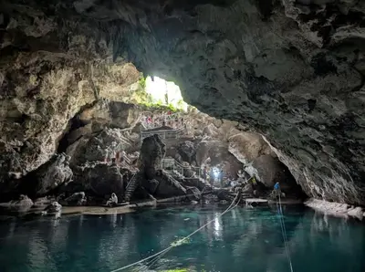 a cave with people standing on a bridge in the water at Civil tower oceance in Santo Domingo