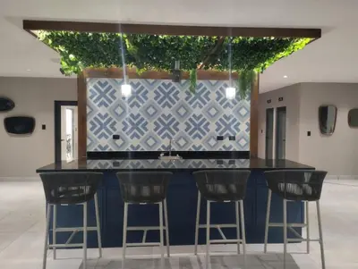 a kitchen with a bar with stools around it at Comfortable oceanfront apartment on Av España in La Francia