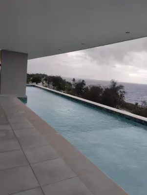 a swimming pool with a view of the ocean at Comfortable oceanfront apartment on Av España in La Francia