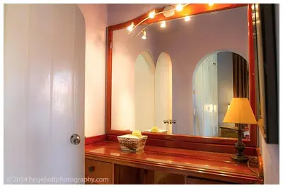 a bathroom with a mirror and a lamp on a counter at Villa Dawn, Bahia de Arena in Cabarete