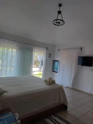a bedroom with a large bed and a window at Villa Cancanet in Nizao