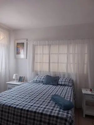 a bedroom with a bed with a blue pillow on it at Villa Cancanet in Nizao