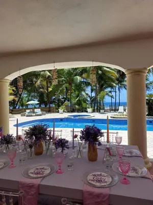 a table set up for a meal next to a pool at Villa Cancanet in Nizao