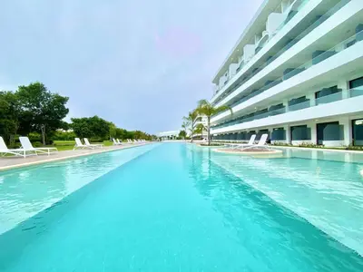 a swimming pool with chairs and a building at 1B Fantasy Lodge @t Canabay Private Pool and beach in Punta Cana