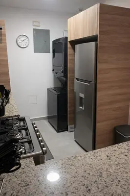 a kitchen with a stove and a refrigerator and a tv at Modern Luxury Apt Pool, Gym and Prime Location in La Julia