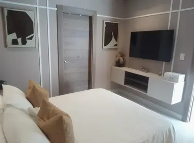 a bedroom with a bed and a flat screen tv at Sky 01 M10 in Santo Domingo