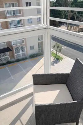 a wicker chair sitting in front of a window at Comfy & Secure Modern 2BR Apartment just 5 minutes from Airport in Boca Chica in Boca Chica