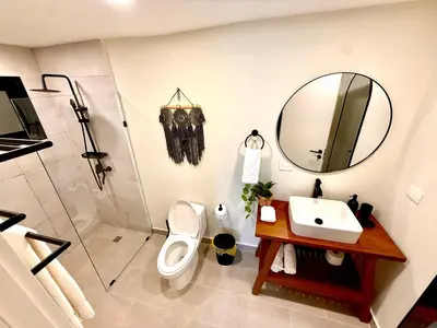 a bathroom with a sink and a toilet and a mirror at Stunning oceanfront apartment in Encuentro at The Wave in Cabarete