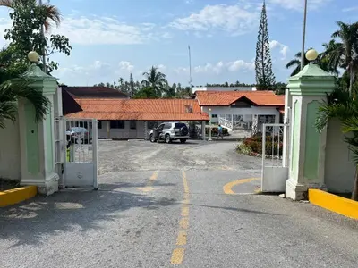 a parking lot with a gate in front of a building at Habitat Samaná Apartments - Coral Samanà