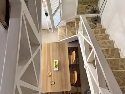 a room with a wooden table and a stair case at Habitat Samaná Apartments - Coral Samanà