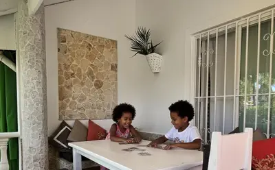 two children sitting at a table in a room at Habitat Samaná Apartments - Coral Samanà