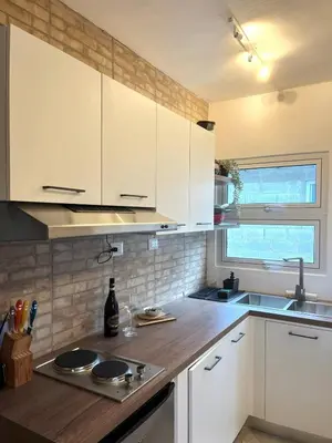 a kitchen with white cabinets and a wooden counter top at Comfortable stay for 4 people in Las Galeras