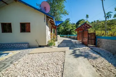 a house with a pathway next to a building at Villa azul círculo auto in Jarabacoa