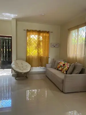 a living room with a couch and a table at Pequeña villa de María in Villa Mella