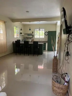 a kitchen and living room with a table and chairs at Pequeña villa de María in Villa Mella