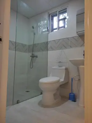 a bathroom with a toilet and a glass shower at Residencial Naime 3 Bristol in San Pedro de Macorís
