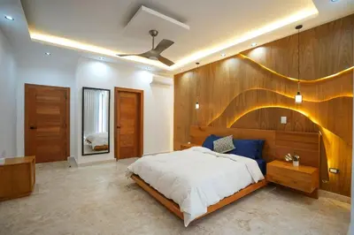 a bedroom with a large bed with a wooden wall at Modern Villa with a 15m Lap Pool, Cabarete in Cabarete