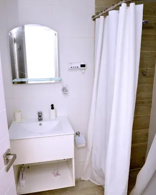 a white bathroom with a sink and a mirror at Peaceful 2BR Retreat with Pool, Paddle Court & Private Beach Access in Punta Cana