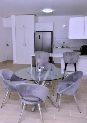 a dining room with a glass table and chairs at Peaceful 2BR Retreat with Pool, Paddle Court & Private Beach Access in Punta Cana