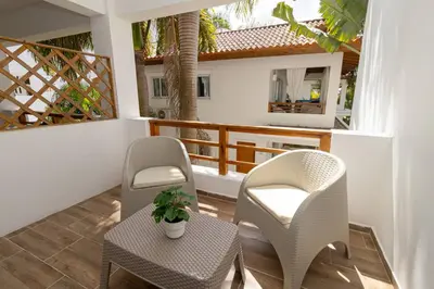 a balcony with two chairs and a table and a table and chairs at Caribbean Escape 1BR at Paraiso Bayahibe in Bayahibe
