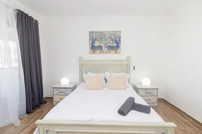 a bedroom with a large white bed with two night stands at Caribbean Escape 1BR at Paraiso Bayahibe in Bayahibe