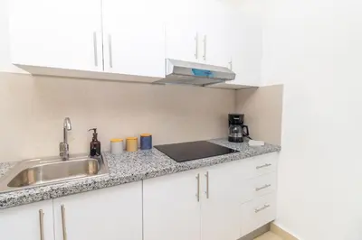 a kitchen with white cabinets and a sink at Caribbean Getaway 2BR at Caribbean Rose Bayahibe in San Rafael del Yuma