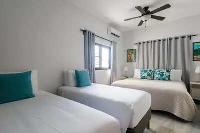 a bedroom with two beds and a ceiling fan at SwellHouseVilla in Cabrera