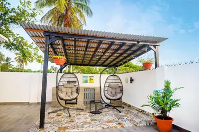 a patio with two chairs under a pergola at SwellHouseVilla in Cabrera