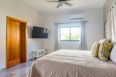 a bedroom with a bed and a flat screen tv at SwellHouseVilla in Cabrera