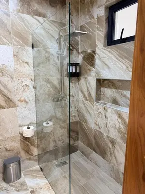 a shower with a glass door in a bathroom at PF Hotel in San Felipe de Puerto Plata