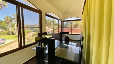 a dining room with a table and some windows at Hideaway Studio - steps from Playa Encuentro at Cabarete in Cabarete