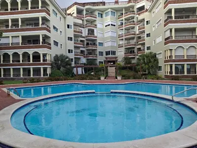 a large swimming pool in front of some apartment buildings at Apartment facing the Caribbean Sea, Juan Dolio Beach in Juan Dolio