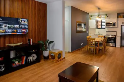 a living room with a table and a kitchen at Spacious Family Home with Sea & Mountain Views in Puerto Plata in San Felipe de Puerto Plata