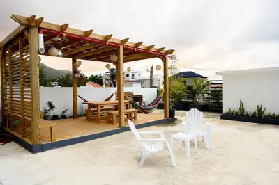 a pavilion with chairs and a hammock on a patio at Spacious Family Home with Sea & Mountain Views in Puerto Plata in San Felipe de Puerto Plata