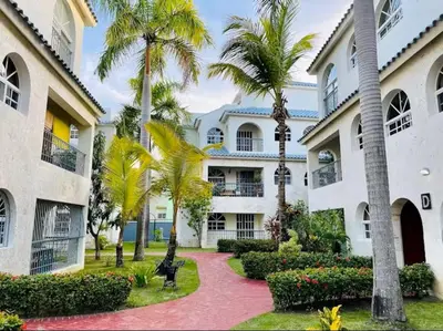 a courtyard of a building with palm trees at Cozy 2BR 2Bth walk 2 the beach Pool view Wi-Fi in Punta Cana