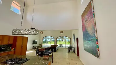 a kitchen and living room with a large painting on the wall at Luxury 2BR Villa - Beach Access and Elegant Design at Cabarete in Cabarete