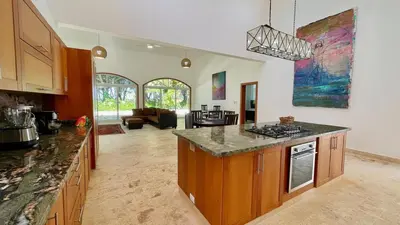 a kitchen with a counter top and a living room at Luxury 2BR Villa - Beach Access and Elegant Design at Cabarete in Cabarete