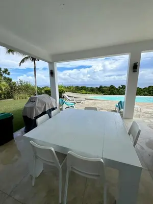 a white table and chairs on a patio at Casa Amalfi Luxury Oceanview Villa with Pool in Cabrera