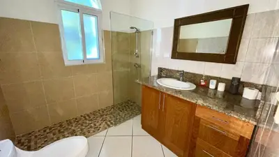 a bathroom with a sink and a toilet and a mirror at 2BR villa & 1BR Guest House, Pool and Beach at Playa Encuentro, Cabarete in Cabarete