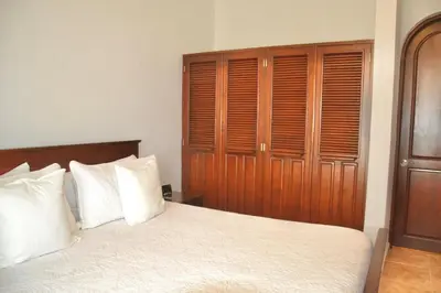 a bedroom with a large bed with wooden cabinets at Beachfront Hideaway 2BR Apartment at Playa Encuentro, Cabarete in Cabarete
