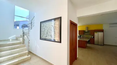 a living room with stairs and a picture on the wall at 3BR Hideaway Lux Villa With Pool & beach Access At Playa Encuentro, Cabarete in Cabarete