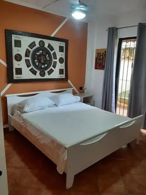 a bed in a room with a clock on the wall at Palm Beach Resort in Boca Chica