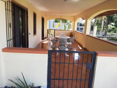 a balcony of a house with a table and chairs at Palm Beach Resort in Boca Chica
