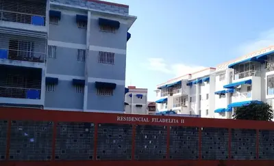 a tall white building with a red fence in front of it at Filadelfia II in La Grúa