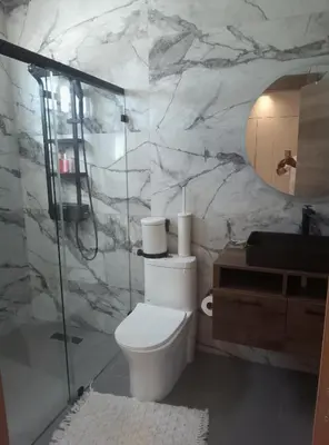 a bathroom with a toilet and a glass shower at Torre Sky 01 M10-2 in Santo Domingo